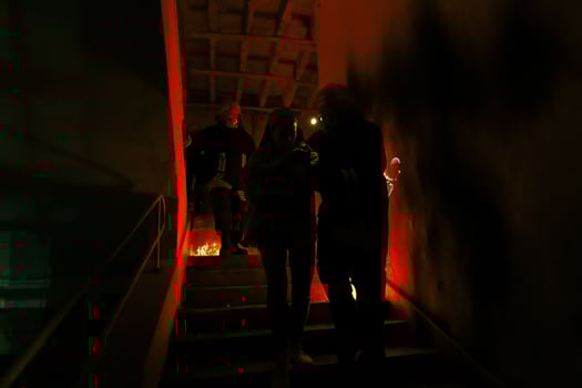 Brave Fireman Descends Stairs of a Burning Building and Holds Saved Girl in His Arms. Open fire and one Firefighter in the Background. photo