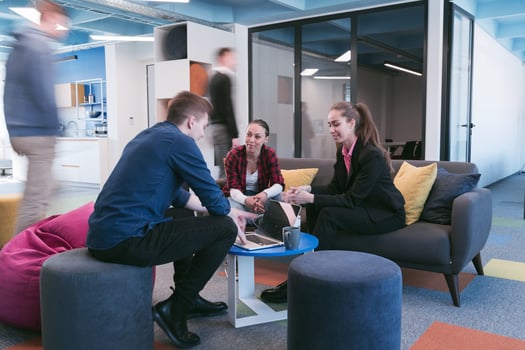 Multiethnic startup business team on meeting in a modern bright open space coworking office. Brainstorming, working on laptop. Group of coworkers walking around in motion blur. photo