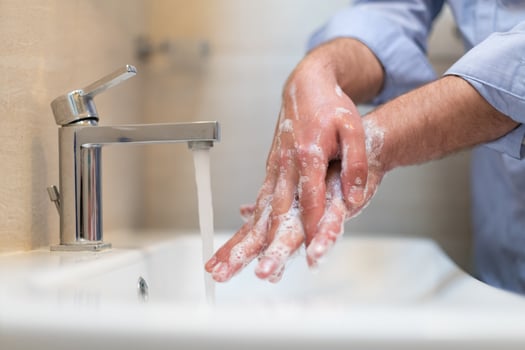 Man using soap and washing hands under the water tap. Hygiene concept hand closeup detail. photo