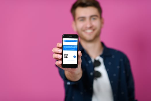 covid passport, a young man shows his code and covid passport on his cell phone photo