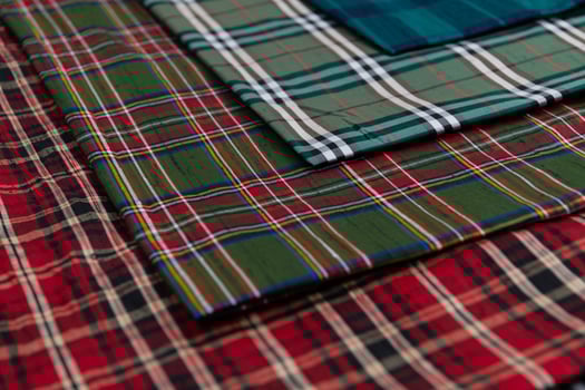 Collection of Scottish fashionable fabrics . Samples of different natural fabrics for sewing a fashion collection of clothes. Large selection of fabrics in the store or tailor warehouse. photo