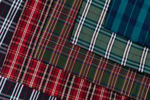 Collection of Scottish fashionable fabrics . Samples of different natural fabrics for sewing a fashion collection of clothes. Large selection of fabrics in the store or tailor warehouse. photo