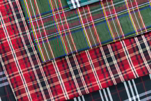 Collection of Scottish fashionable fabrics . Samples of different natural fabrics for sewing a fashion collection of clothes. Large selection of fabrics in the store or tailor warehouse. photo