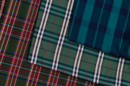 Collection of Scottish fashionable fabrics . Samples of different natural fabrics for sewing a fashion collection of clothes. Large selection of fabrics in the store or tailor warehouse. photo