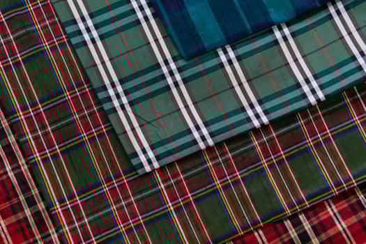 Collection of Scottish fashionable fabrics . Samples of different natural fabrics for sewing a fashion collection of clothes. Large selection of fabrics in the store or tailor warehouse. photo
