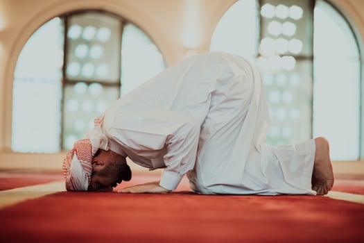 A Muslim praying in a modern mosque during the holy Muslim month of Ramadan photo
