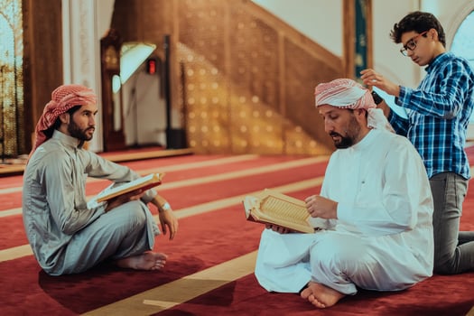 A group of Muslims reading the holy book of the Quran in a modern mosque during the Muslim holiday of Ramadan photo