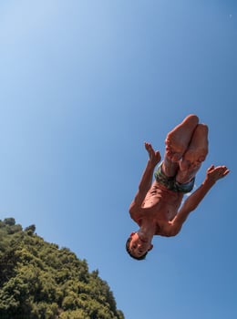 a man in a swimsuit is jumping into the water photo