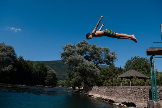 a man in a swimsuit is jumping into the water photo