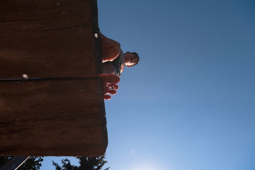 a person standing on a wooden platform with their feet in the air photo