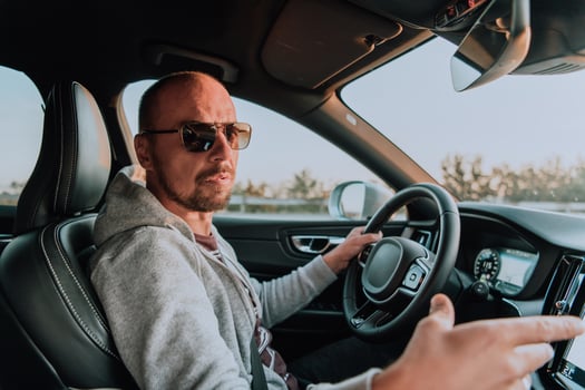 A man with a sunglasses driving a car at sunset. The concept of car travel photo