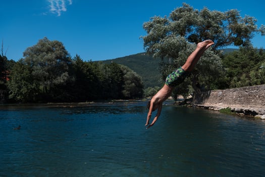 a man in a swimsuit is jumping into the water photo