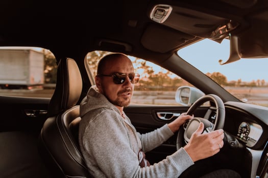 A man with a sunglasses driving a car at sunset. The concept of car travel photo