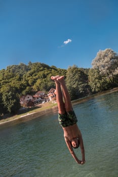 a man in a swimsuit is jumping into the water photo