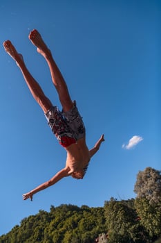 a man in a swimsuit is doing a flip in the air photo