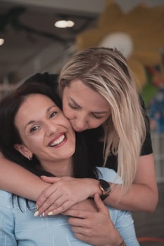Portrait of two hugging female teachers in a preschool institution, in the background of the classrooms photo