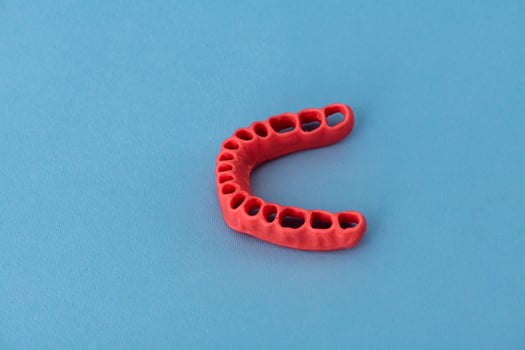 human gums without teeth model medical implant isolated on blue background. Healthy teeth, dental care and orthodontic concept. photo
