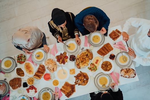 Top view of Muslim family having Iftar dinner drinking water to break feast. Eating traditional food during Ramadan feasting month at home. The Islamic Halal Eating and Drinking in modern home photo