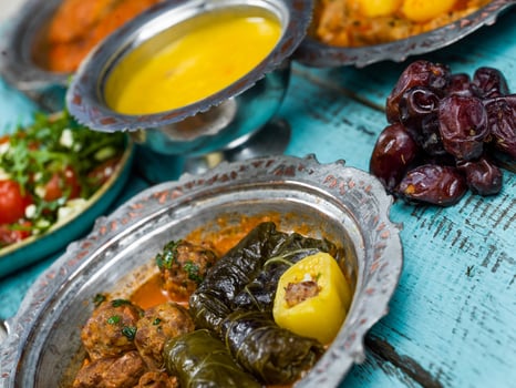 Eid Mubarak Traditional Ramadan Iftar dinner. Assorted tasty food in authentic rustic dishes on wooden blue background. Turkish Bosnian food meat kebab, pita, Sarma, klepe, sogan dolma. photo