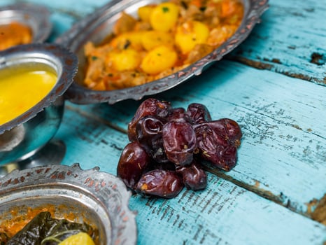 Eid Mubarak Traditional Ramadan Iftar dinner. Assorted tasty food in authentic rustic dishes on wooden blue background. Turkish Bosnian food meat kebab, pita, Sarma, klepe, sogan dolma. photo