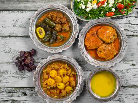 Eid Mubarak Traditional Ramadan Iftar dinner. Assorted tasty food in authentic rustic dishes on wooden blue background. Turkish Bosnian food meat kebab, pita, Sarma, klepe, sogan dolma. photo