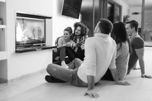multiethnic couples sitting in front of fireplace photo