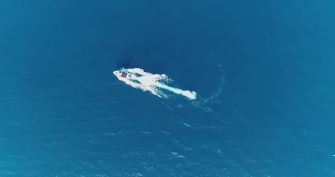 Aerial top view of a white pleasure boat on a summer day. Powerboat turn loop eight on the sea making infinity future concept. photo
