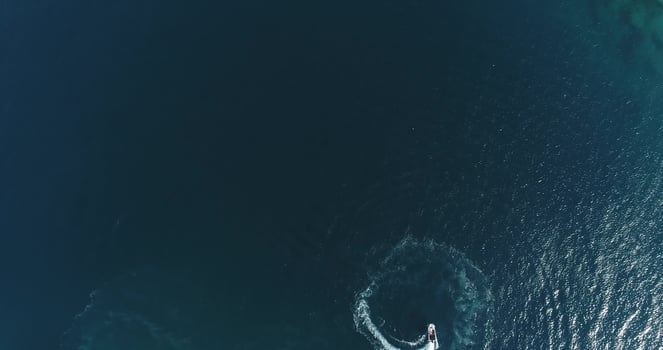 Aerial top view of a white pleasure boat on a summer day. Powerboat turn loop eight on the sea making infinity future concept. photo