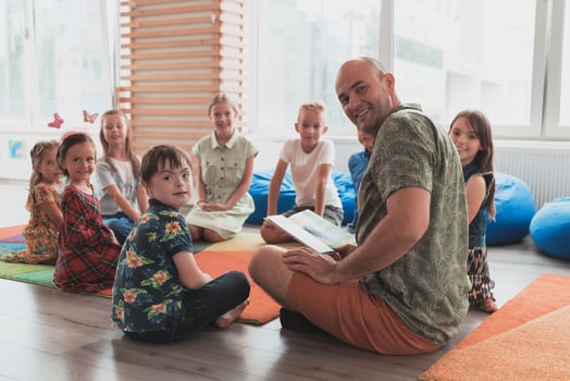 Reading time in elementary school or kindergarten, teacher reading a book to kids in elementary school or kindergaden. Selective focus photo