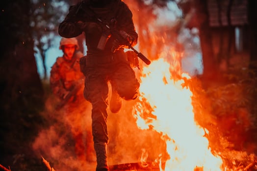 Soldier in Action at Night in the Forest Area. Night Time Military Mission jumping over fire photo