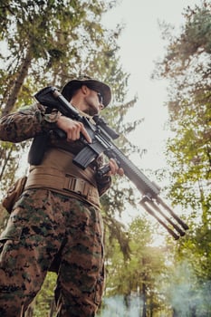Soldier portrait with protective army tactical gear and weapon having a break and relaxing photo