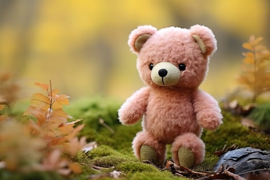 cute pink teddy toy bear on blurred forest autumn background photo