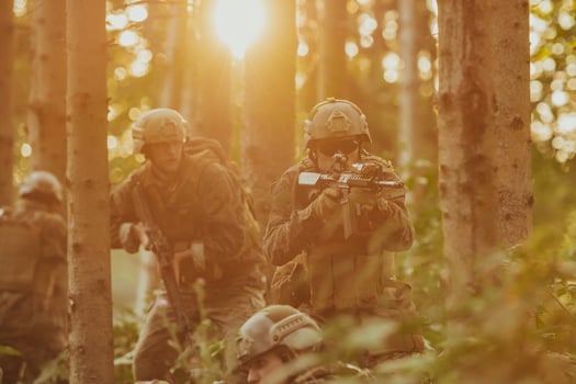 A group of modern warfare soldiers is fighting a war in dangerous remote forest areas. A group of soldiers is fighting on the enemy line with modern weapons. The concept of warfare and military conflicts photo