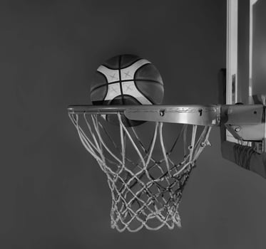 basketball ball falling into the basket on a black background photo