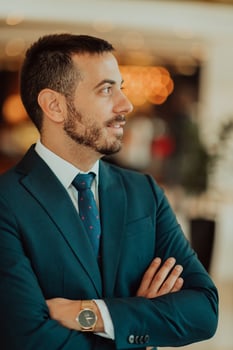 Portrait of a businessman in a suit with his arms crossed in a modern office building photo