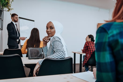 African American Muslim woman listens to a lecture aimed at business training photo