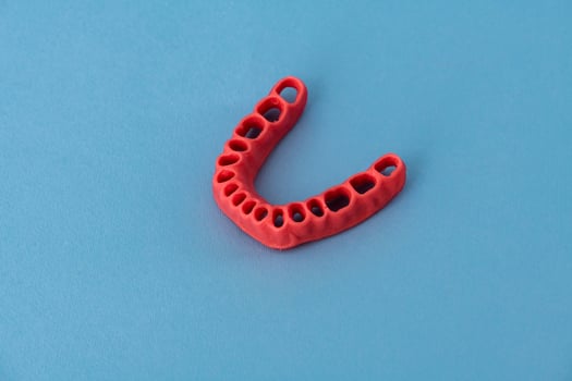 human gums without teeth model medical implant isolated on blue background. Healthy teeth, dental care and orthodontic concept. photo