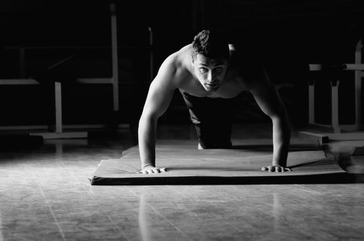 young man with strong arms working out in gym photo