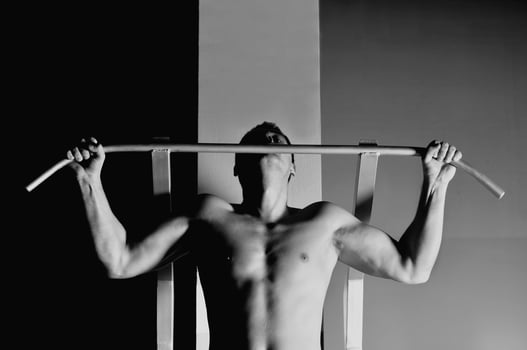 young man with strong arms working out in gym photo