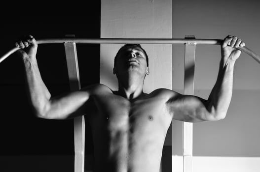 young man with strong arms working out in gym photo