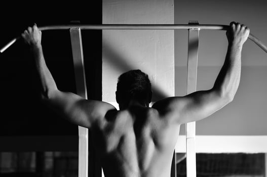 young man with strong arms working out in gym photo