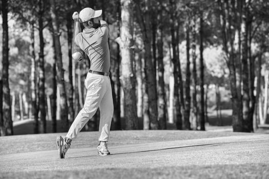 golf player hitting shot with club photo