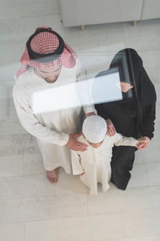 Portrait of a young happy Arabian Muslim family couple with a son in traditional clothes spending time together photo