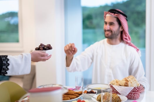 modern multiethnic muslim family sharing a bowl of dates while enjoying iftar dinner together during a ramadan feast at home photo