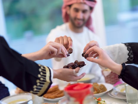 modern multiethnic muslim family sharing a bowl of dates while enjoying iftar dinner together during a ramadan feast at home photo