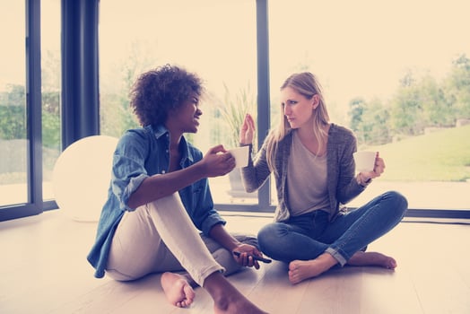 multiethnic women sit on the floor and drinking coffee photo