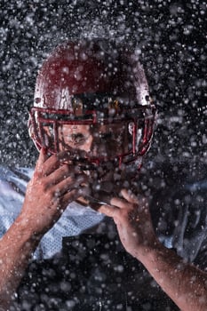 American Football Field Lonely Athlete Warrior Standing on a Field Holds his Helmet and Ready to Play. Player Preparing to Run, Attack and Score Touchdown. Rainy Night with Dramatic Fog, Blue Light photo