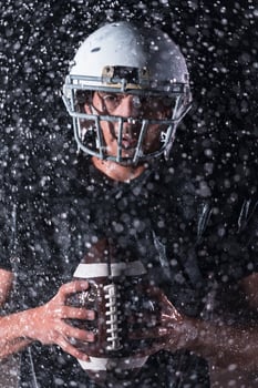 American Football Field Lonely Athlete Warrior Standing on a Field Holds his Helmet and Ready to Play. Player Preparing to Run, Attack and Score Touchdown. Rainy Night with Dramatic Fog, Blue Light photo