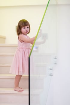 little girl playing on stairs at home photo