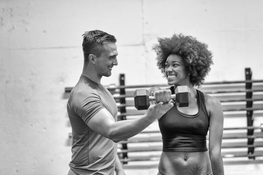 black woman doing bicep curls with fitness trainer photo